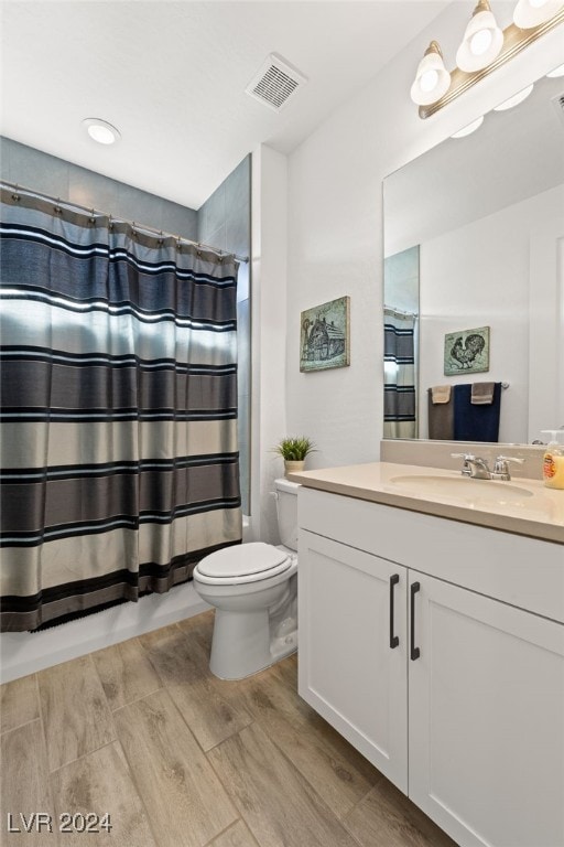 bathroom with vanity, hardwood / wood-style floors, and toilet