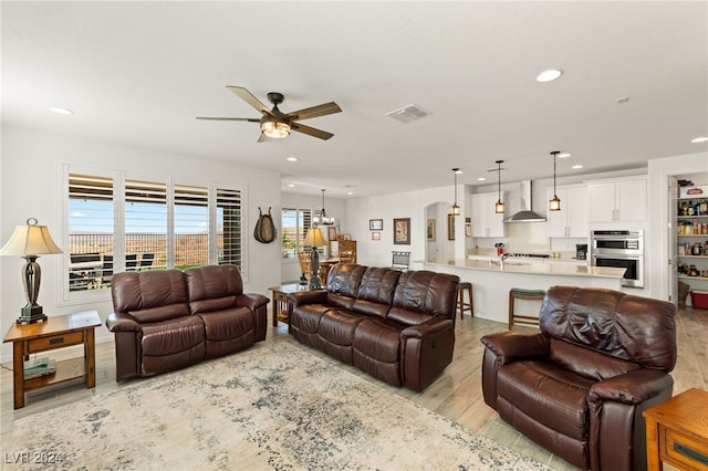 living room with sink, light hardwood / wood-style flooring, and ceiling fan