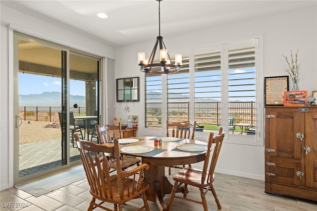 dining room featuring an inviting chandelier, a mountain view, and light wood-type flooring