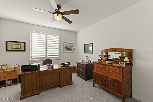 carpeted home office featuring ceiling fan