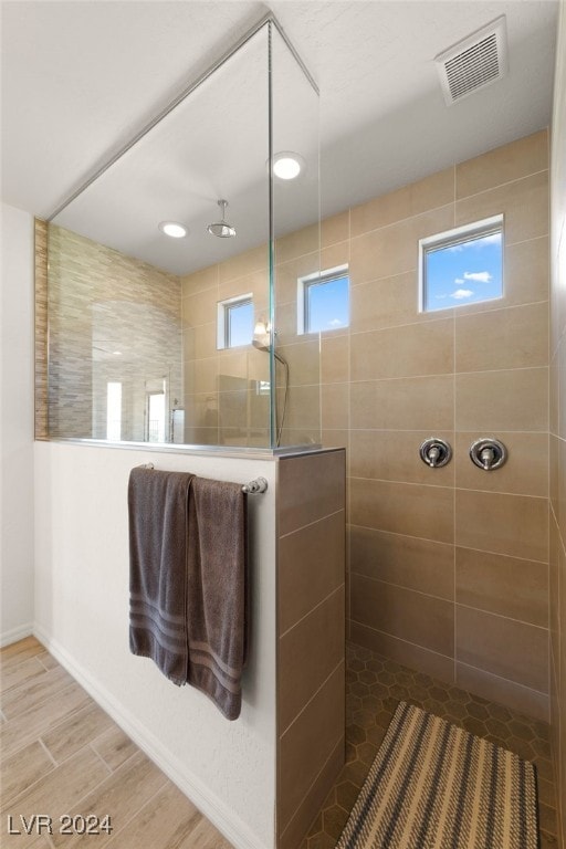 bathroom featuring wood-type flooring and tiled shower