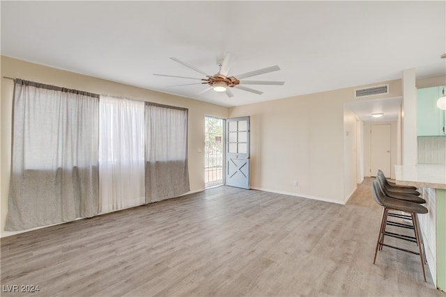 unfurnished living room featuring ceiling fan and light hardwood / wood-style floors