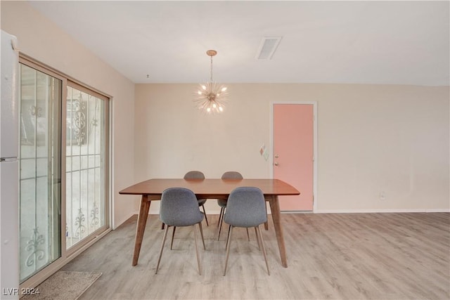 dining space with a notable chandelier, visible vents, light wood-style flooring, and baseboards