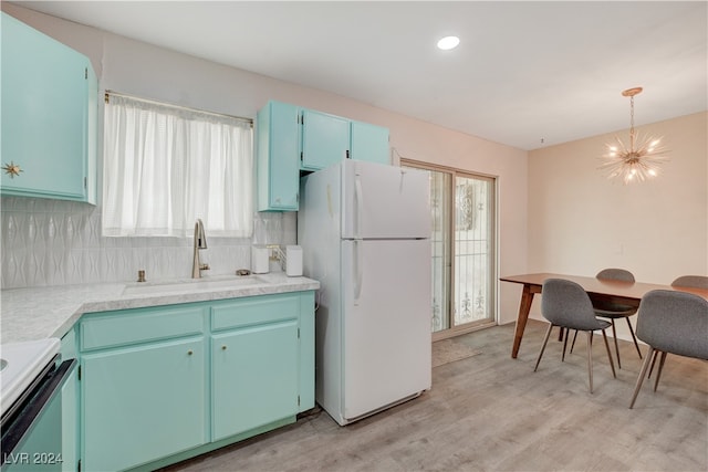 kitchen featuring white appliances, sink, hanging light fixtures, light hardwood / wood-style flooring, and plenty of natural light