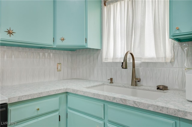 kitchen featuring decorative backsplash, green cabinetry, and sink