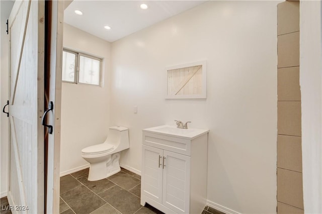 bathroom with vanity, baseboards, recessed lighting, tile patterned flooring, and toilet