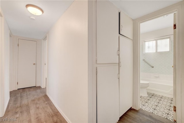 hallway with baseboards and light wood finished floors