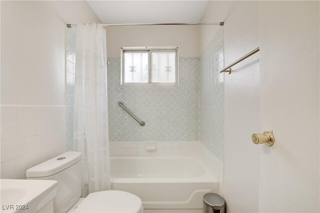 bathroom featuring toilet, tile walls, and shower / bathtub combination with curtain