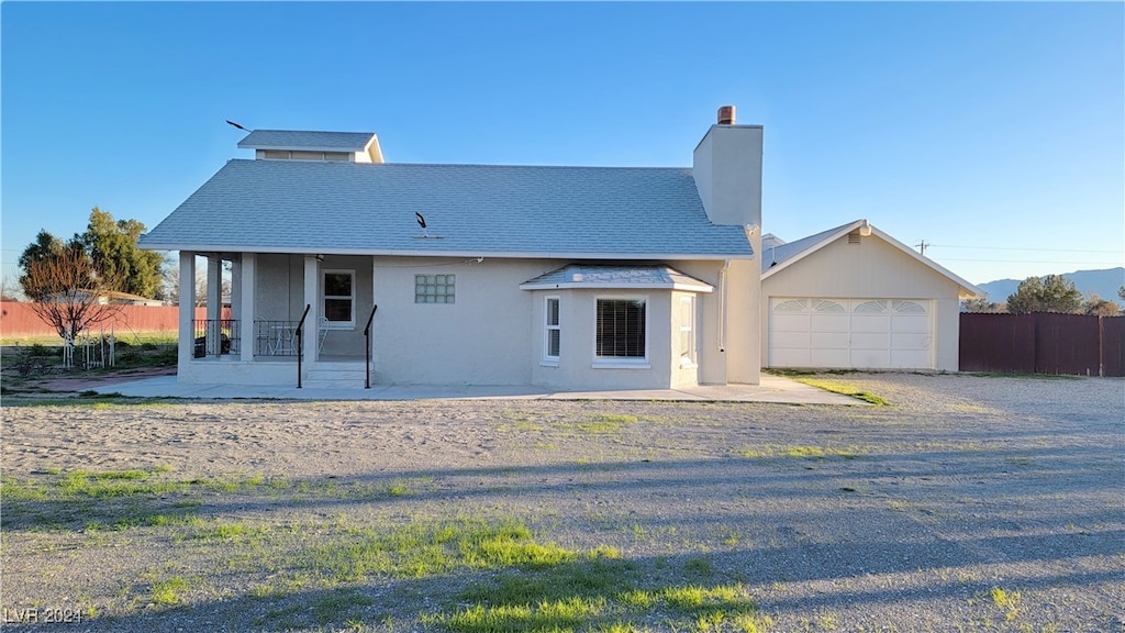 back of property featuring a garage and a patio area