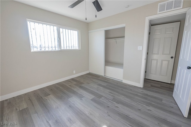 unfurnished bedroom featuring a closet, wood-type flooring, and ceiling fan