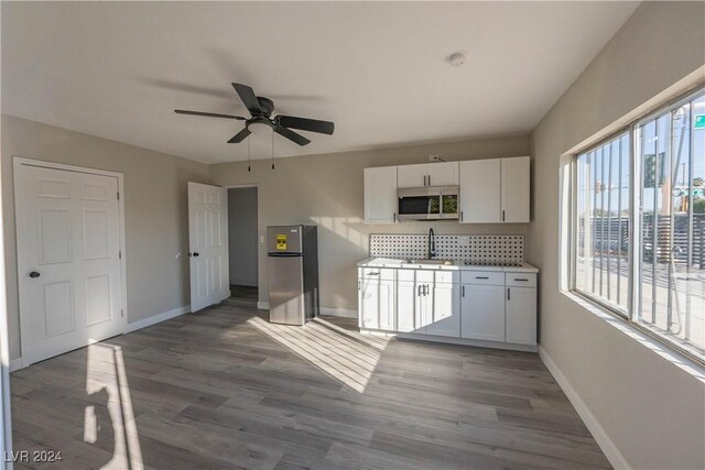 kitchen featuring hardwood / wood-style floors, appliances with stainless steel finishes, plenty of natural light, and ceiling fan