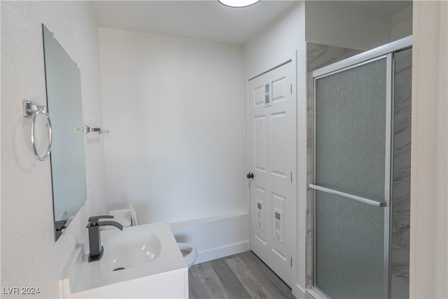 bathroom with vanity, an enclosed shower, and hardwood / wood-style flooring