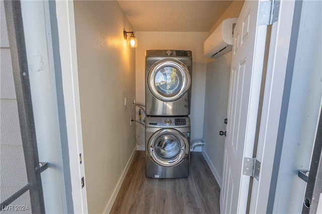 laundry room featuring hardwood / wood-style flooring, an AC wall unit, and stacked washer and clothes dryer