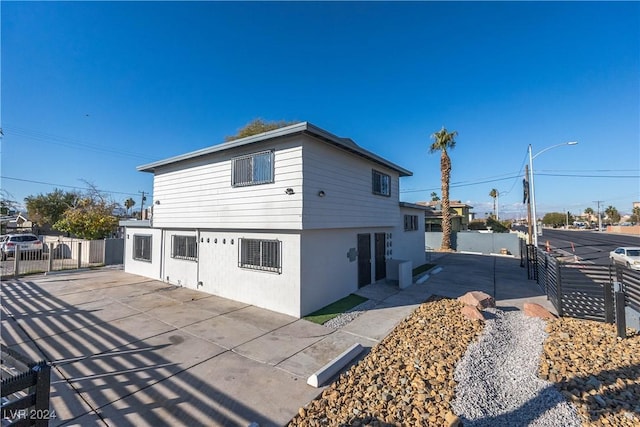 back of house with a patio, fence, and stucco siding