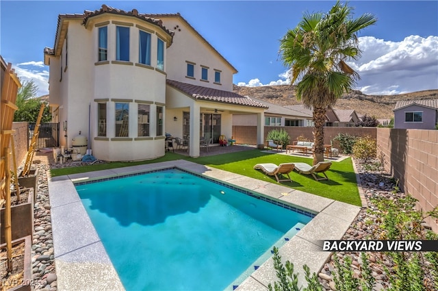 back of property with a fenced in pool and a patio area