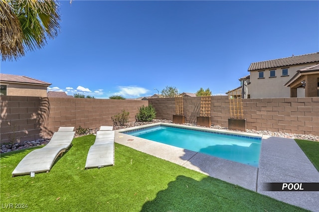 view of pool featuring a lawn