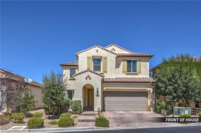 mediterranean / spanish-style home with a garage