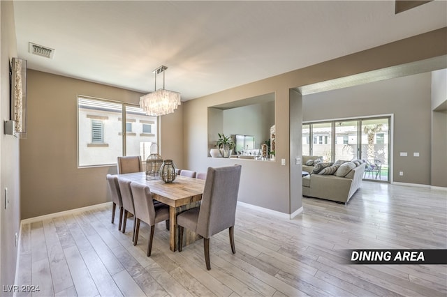 dining area featuring light hardwood / wood-style floors and a notable chandelier