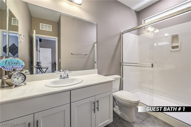 bathroom featuring tile patterned floors, a shower with shower door, toilet, and vanity