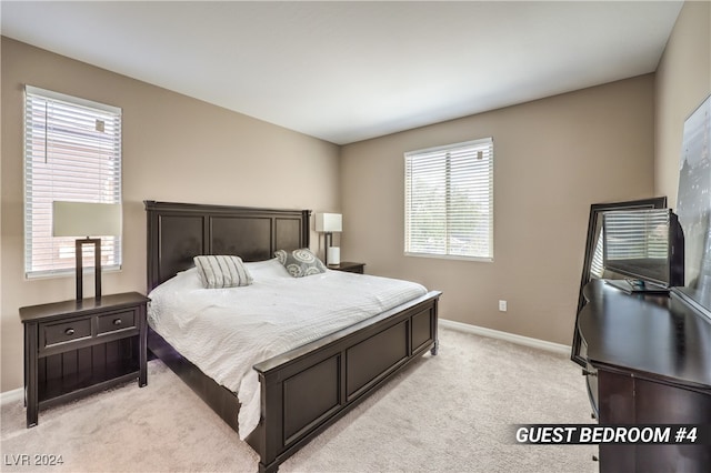 bedroom with light carpet and multiple windows