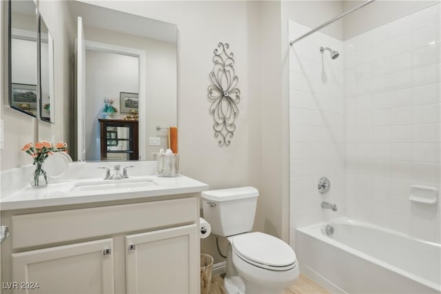 full bathroom with tiled shower / bath, vanity, and toilet