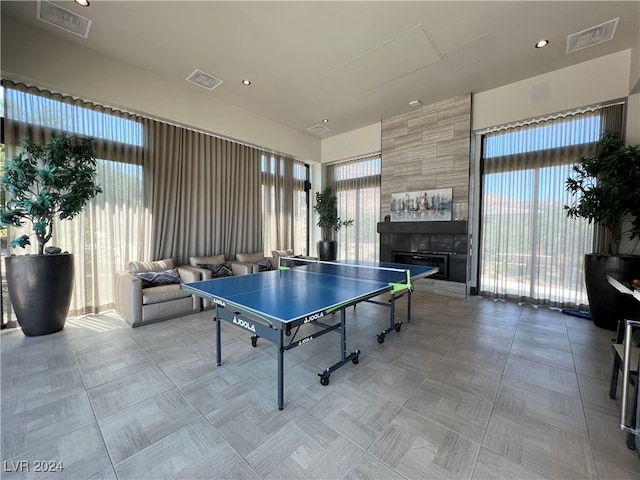 rec room with a tiled fireplace and a wealth of natural light