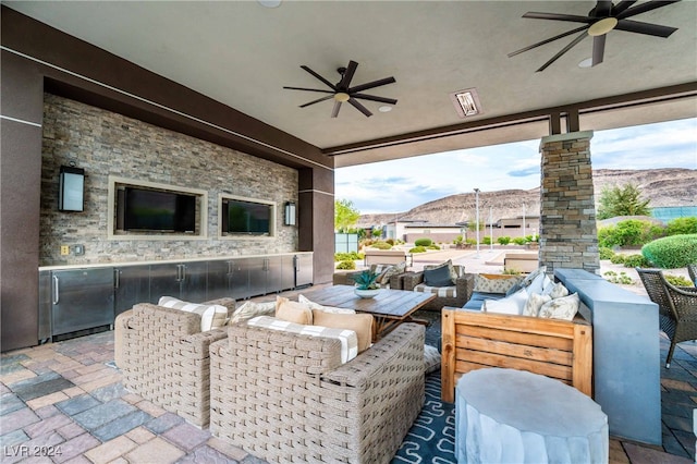 view of patio featuring an outdoor hangout area, ceiling fan, and exterior bar