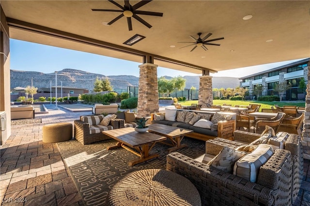 view of patio featuring ceiling fan, an outdoor hangout area, and a mountain view