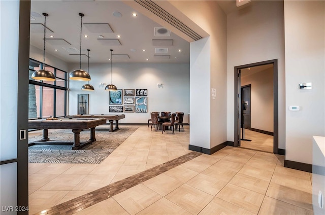 game room with light tile patterned flooring, a towering ceiling, and pool table