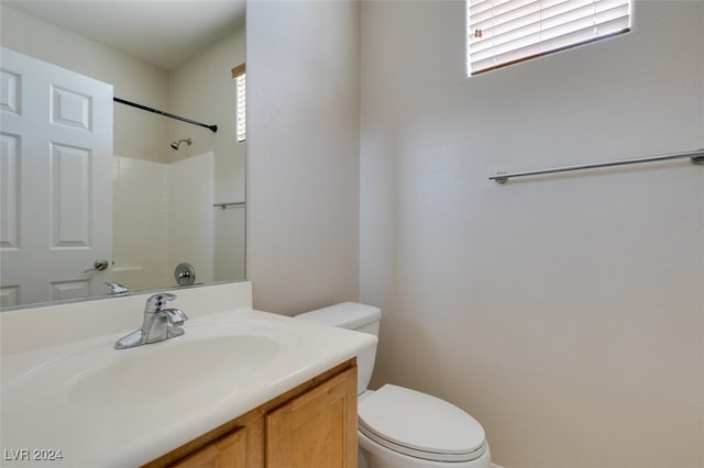 bathroom featuring vanity, toilet, and a shower