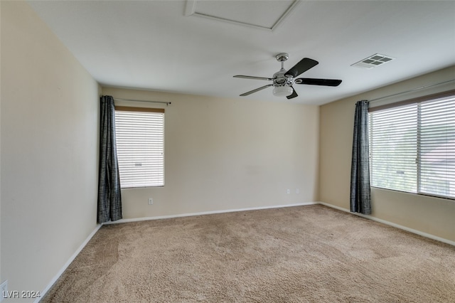 carpeted spare room with a healthy amount of sunlight and ceiling fan