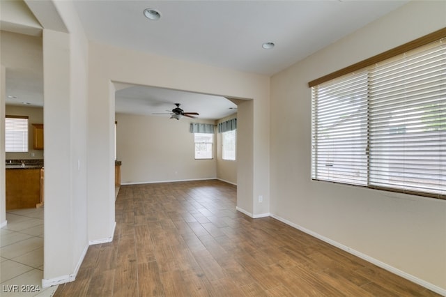 spare room with ceiling fan and light wood-type flooring