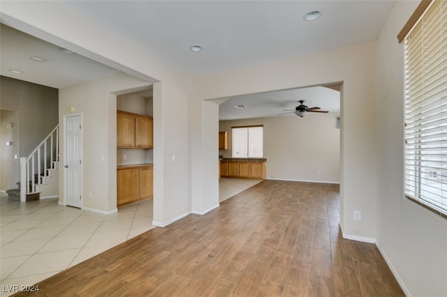 unfurnished living room featuring ceiling fan and light hardwood / wood-style floors