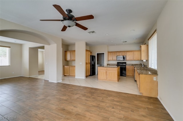 kitchen with a kitchen island, black appliances, light hardwood / wood-style floors, light brown cabinets, and ceiling fan