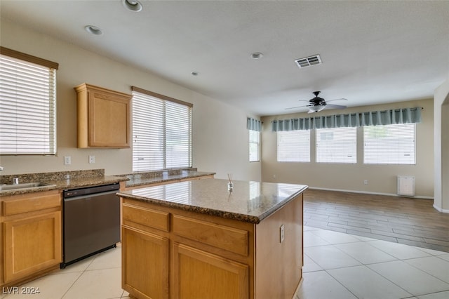 kitchen featuring dishwasher, stone countertops, a center island, ceiling fan, and light wood-type flooring