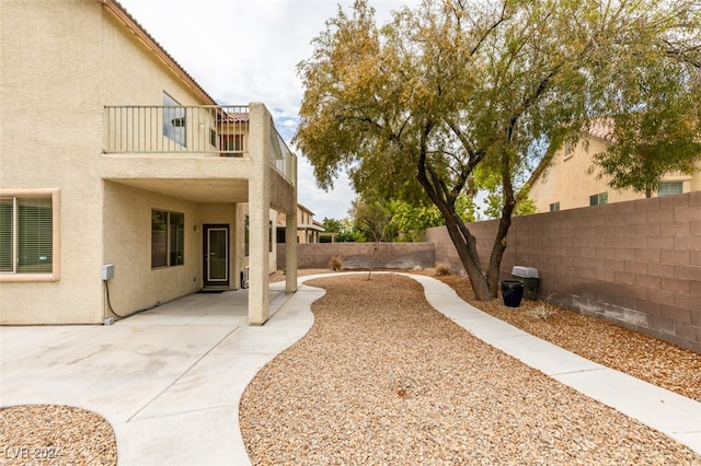 view of yard featuring a patio and a balcony