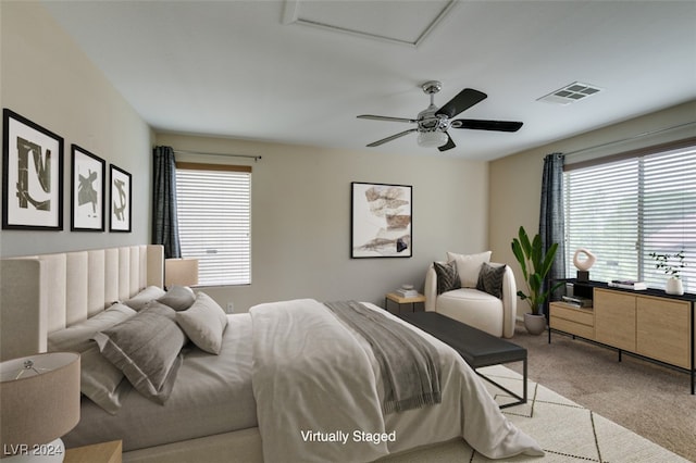 bedroom featuring light carpet, multiple windows, and ceiling fan