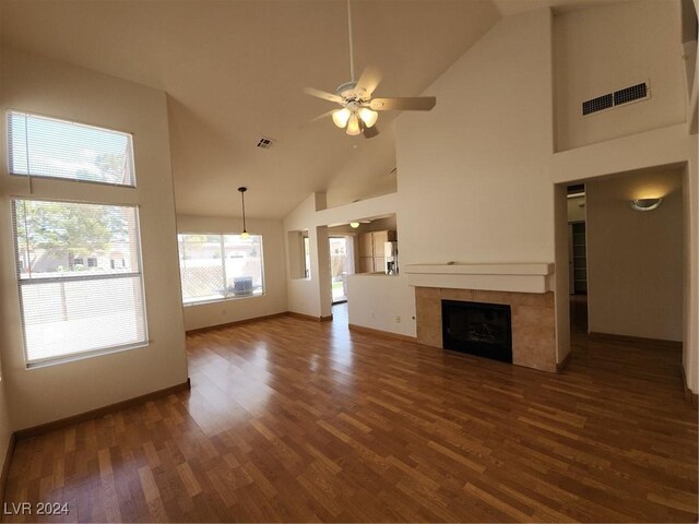 unfurnished living room with ceiling fan, high vaulted ceiling, and a fireplace