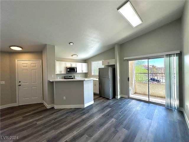 kitchen with lofted ceiling, stainless steel appliances, dark hardwood / wood-style flooring, and white cabinets