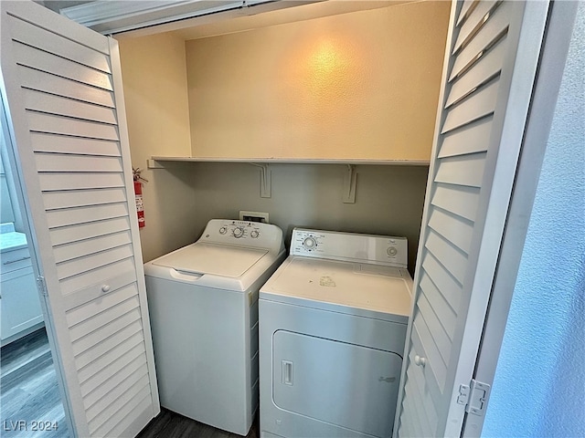 laundry room with dark hardwood / wood-style flooring and washing machine and dryer