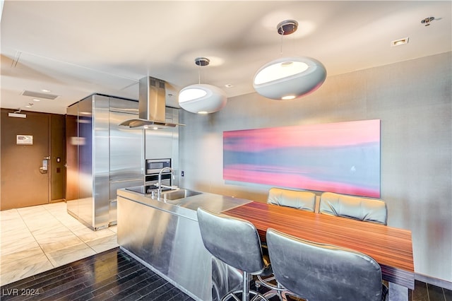 interior space with island exhaust hood and a sink