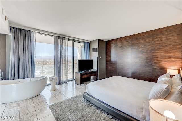 bedroom with marble finish floor, access to outside, and floor to ceiling windows