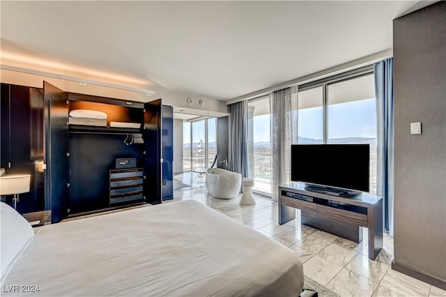 bedroom featuring access to outside, marble finish floor, and expansive windows