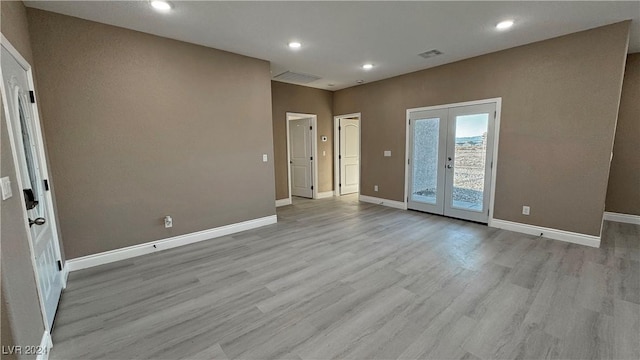 unfurnished room featuring french doors and light wood-type flooring