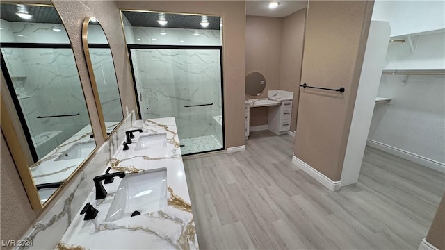 bathroom with hardwood / wood-style floors, vanity, and an enclosed shower