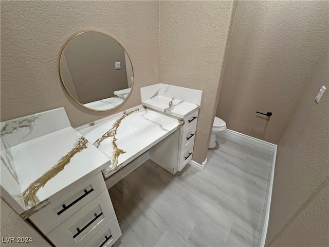 bathroom with vanity, hardwood / wood-style flooring, and toilet