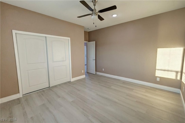 unfurnished bedroom featuring ceiling fan, a closet, and light hardwood / wood-style floors