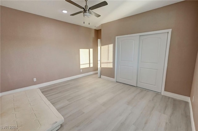 unfurnished bedroom featuring ceiling fan, a closet, and light hardwood / wood-style floors