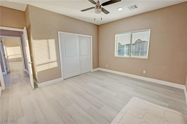 unfurnished bedroom with light wood-type flooring, a closet, and ceiling fan