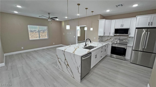 kitchen featuring sink, stainless steel appliances, kitchen peninsula, pendant lighting, and white cabinets